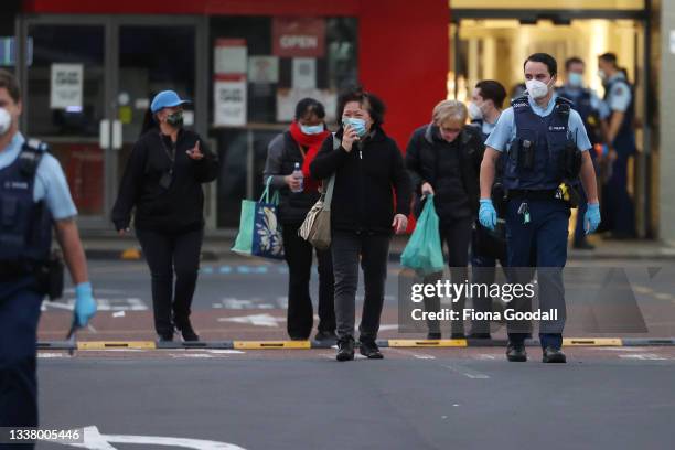 Police escort people from LynnMall to their cars after a violent extremist took out a terrorist attack stabbing six people before being shot by...