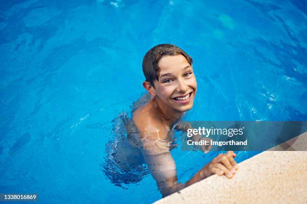 little boy enjoying swimming in swimming pool - boy swimming pool stock pictures, royalty-free photos & images