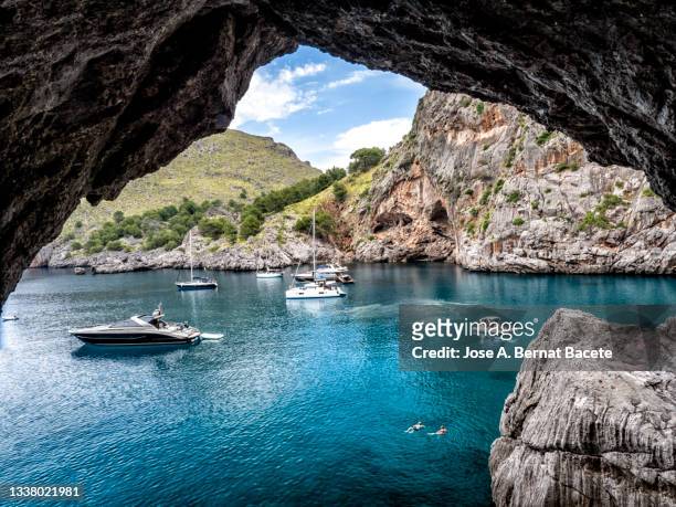 boats and yachts  in a cove between mountains and cliffs of the mediterranean sea. cala sa calobra, majorca island. - maiorca stock-fotos und bilder