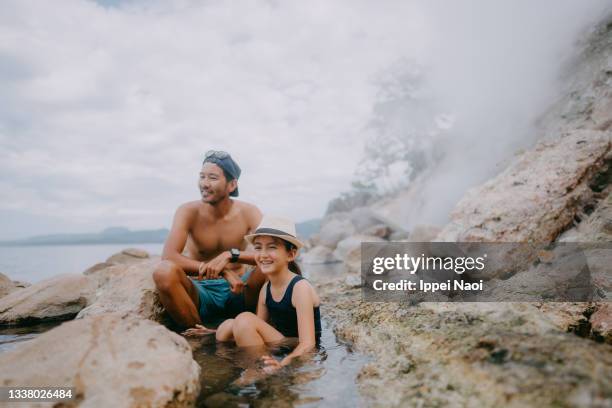 father and young daughter enjoying hot spring bath by the lake, japan - hokkaido - fotografias e filmes do acervo