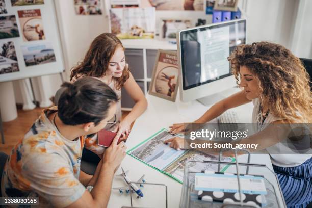 young couple planning on vacation - travel agency stock pictures, royalty-free photos & images