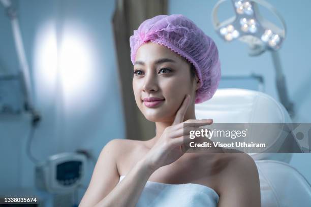 cosmetic surgery,girl hand touch cheek and smile attractive,skin healthcare concept. - operating model photos et images de collection