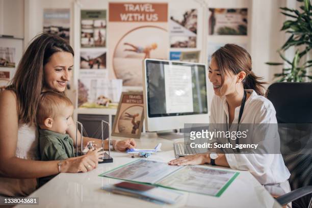 mother and little son planning vacation - travel agency stock pictures, royalty-free photos & images