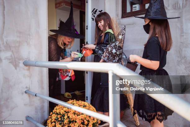 children masked as witches trick and treating for halloween - witch's hat stock pictures, royalty-free photos & images