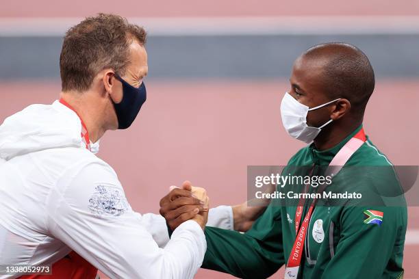 Silver medalist Richard Whitehead of Team Great Britain and gold medalist Ntando Mahlangu of Team South Africa celebrate during the medal ceremony...