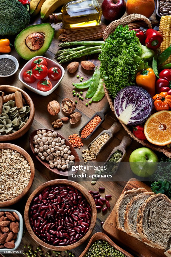 High angle view of dietary fiber fresh vegan food and legumes on rustic wooden table. Healthy food themes.