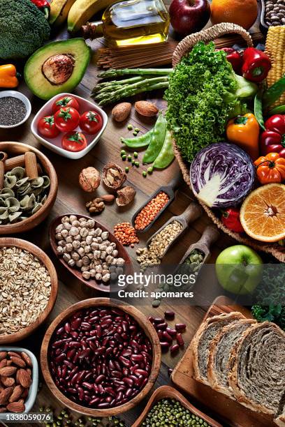 high angle view of dietary fiber fresh vegan food and legumes on rustic wooden table. healthy food themes. - carbs bildbanksfoton och bilder