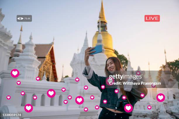 young female tourist holding a gimbal with smartphone and recording videos. travel blogger and vlogger concept - live event camera stock pictures, royalty-free photos & images