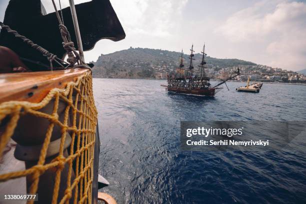 old pirate ship on the water of mediteranean sea. tourist entertainment, coastal tour. summer sunny day. mountain shore of alanya. turkey. - antalya city stock-fotos und bilder