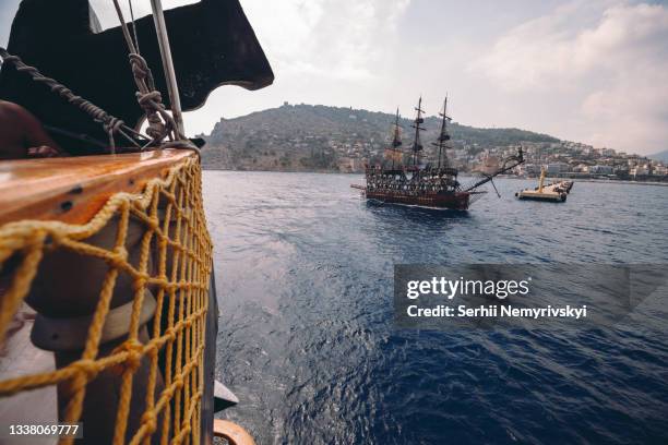 old pirate ship on the water of mediteranean sea. tourist entertainment, coastal tour. summer sunny day. mountain shore of alanya. turkey. - pirata imagens e fotografias de stock