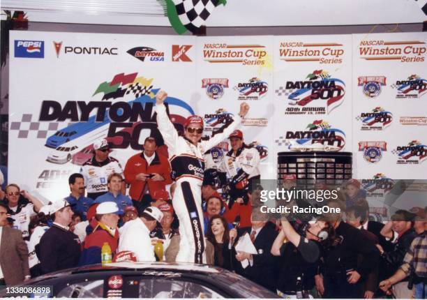 Dale Earnhardt, with wife Teresa Earnhardt bottom center, climbs out of his car and celebrates his first Daytona 500 win following his victory in...