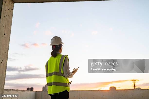 young female engineer using digital tablet on construction site - work gender equality stock pictures, royalty-free photos & images