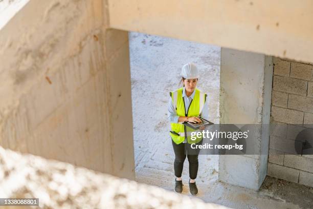 junge ingenieurin mit digitalem tablet auf der baustelle - cb funk stock-fotos und bilder