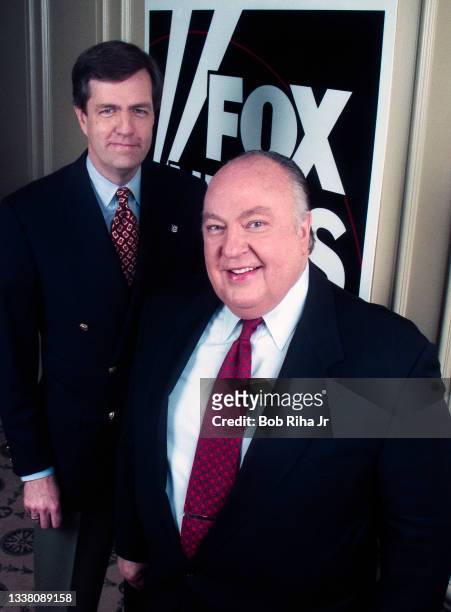 Portrait of American television executive and Chairman of Fox News Roger Ailes with Brit Hume in front of logo of the recently launched Fox News...