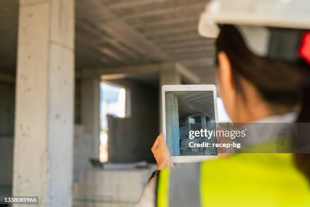 ingeniera usando tableta digital en el sitio de construcción - ingeniero civil fotografías e imágenes de stock