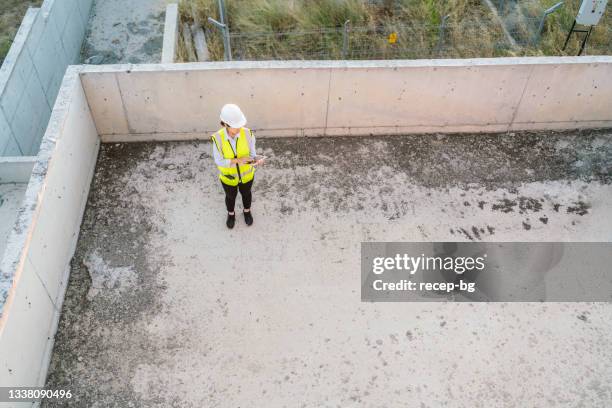 young female engineer using digital tablet on construction site - looking over balcony stock pictures, royalty-free photos & images