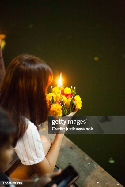 jovem tailandesa está rezando em loi krathong - loi krathong - fotografias e filmes do acervo