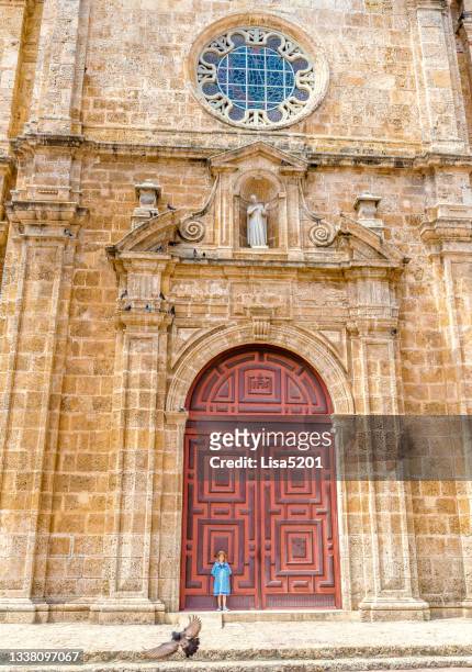una niña, en una antigua puerta, cartagena colombia, palomas y la catedral - lisa kirk fotografías e imágenes de stock