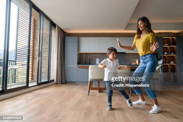 happy mother having fun dancing with her son at home - nanny stock pictures, royalty-free photos & images