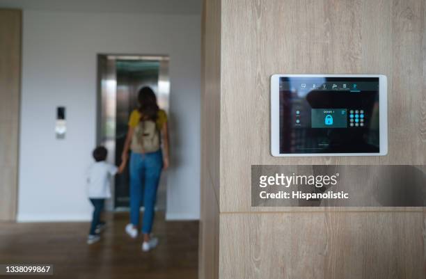 mother and son leaving the house and locking the door using an automated security system - alarm system stock pictures, royalty-free photos & images