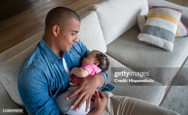 happy father bonding with his newborn baby at home - father holding sleeping baby imagens e fotografias de stock