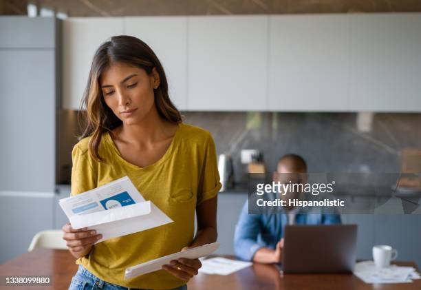 woman at home looking worried getting bills in the mail - tenant imagens e fotografias de stock