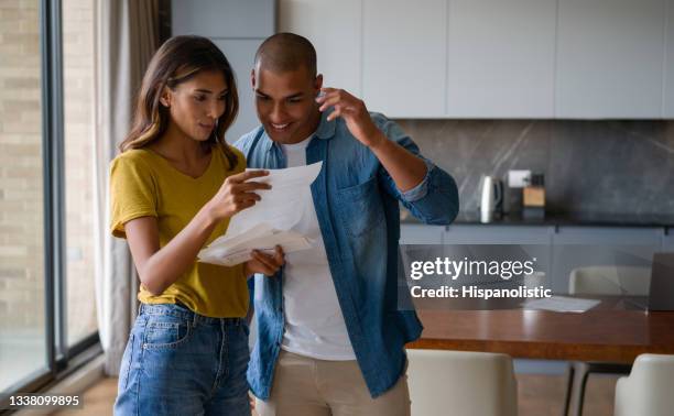 happy couple reading good news in a letter that came in the mail - good news stock pictures, royalty-free photos & images