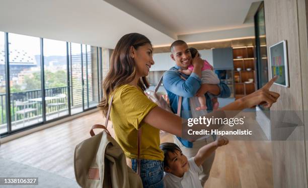 happy family leaving the house locking the door using automated security system - domotic stockfoto's en -beelden