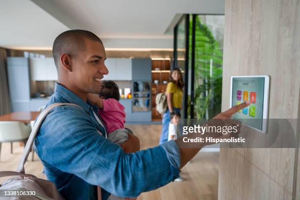 happy family leaving the house locking the door using a home automation system - smart house stock pictures, royalty-free photos & images