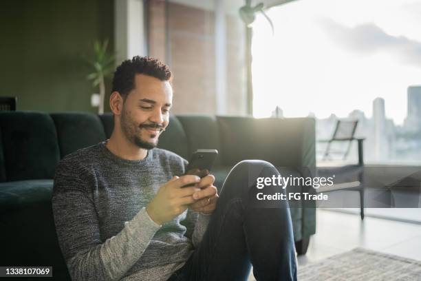 man using smartphone at home - man on mobile phone stock pictures, royalty-free photos & images