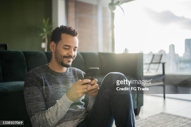 man using smartphone at home - candid forum 個照片及圖片檔