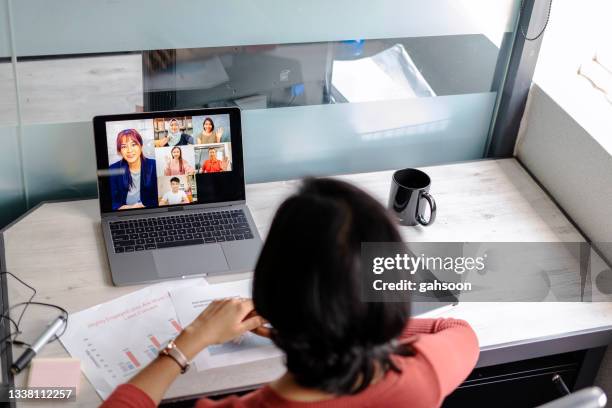 woman video call with multi racial colleagues in office - makeshift office stock pictures, royalty-free photos & images