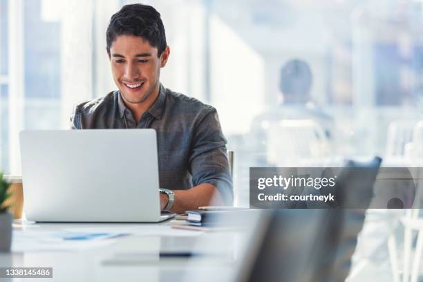 uomo d'affari che lavora su un computer portatile in ufficio - usare il laptop foto e immagini stock