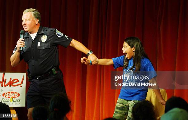 Girl screams as Santa Ana police officer Mike Fuller demonstrates how quickly a child can be kidnapped on Kid's Safety Day at the Discovery Science...