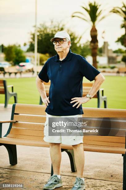 medium wide shot of senior man lawn bowling on summer evening - navy blue polo shirt stock pictures, royalty-free photos & images