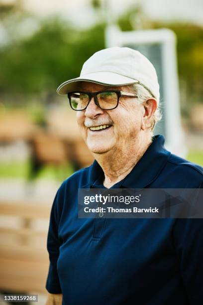 medium shot portrait of smiling senior man lawn bowling on summer evening - navy blue polo shirt stock pictures, royalty-free photos & images