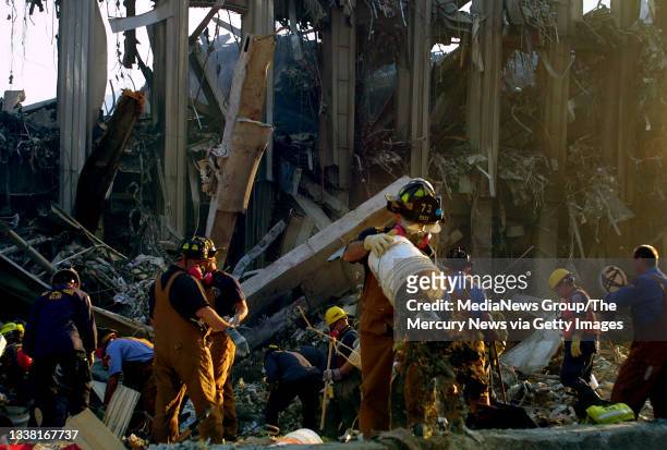 Rescue workers use a bucket line to go through debris during the early morning hours of September 23, 2001 at "ground zero" of the destroyed World...