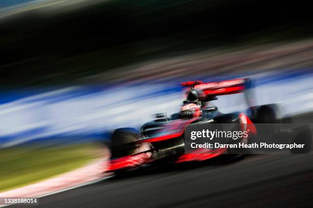 British McLaren Ferrari Formula One team racing driver Jenson Button driving his MP4-27 racing car at speed through the 'S' curves during practice...