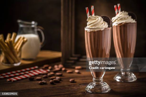 two chocolate milkshakes on a wooden table - chocolate milkshake stock pictures, royalty-free photos & images