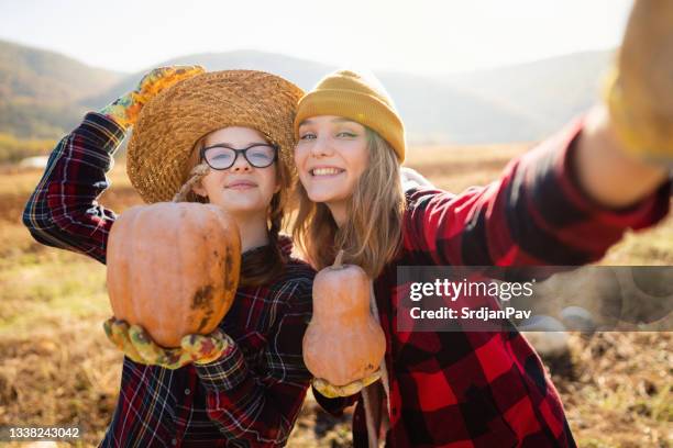 de jeunes agricultrices joyeuses font un selfie avec des citrouilles après la récolte - agriculteur selfie photos et images de collection