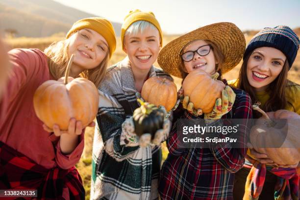 femmes joyeuses faisant un selfie avec des citrouilles après la récolte - agriculteur selfie photos et images de collection