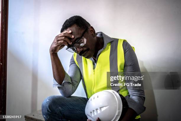 erschöpfter bauarbeiter auf der baustelle - stress arbeitsplatz stock-fotos und bilder