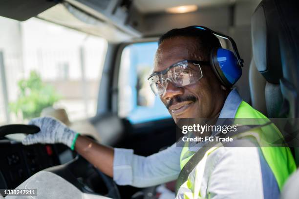 portrait of a trucker driver inside the truck at a construction site - ear protection stock pictures, royalty-free photos & images