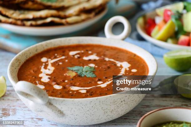 bild von kadhai-art servierschüssel mit hausgemachtem dal makhani curry rezept, teller mit knoblauch naan brot auf türkis, holzschneidebrett, beilagensalat, gericht aus minze und koriander dip, blauer musselin, fokus auf vordergrund - dal stock-fotos und bilder