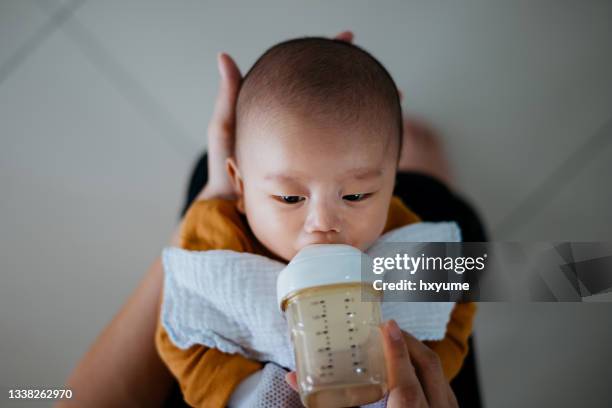 asian baby drinking milk with a baby bottle - mjölkflaska bildbanksfoton och bilder