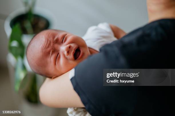 frau mit einem weinenden baby - babys crying stock-fotos und bilder