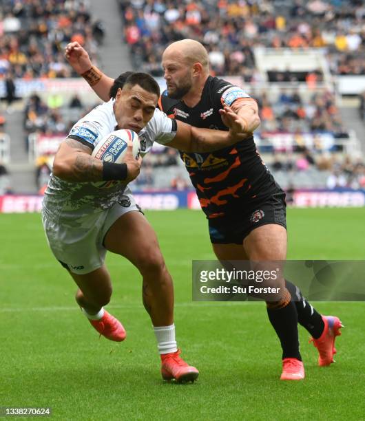 Devils player Ken Sio holds off the tackle of tigers player George Griffin to score the first Devils try during the Betfred Super League match...