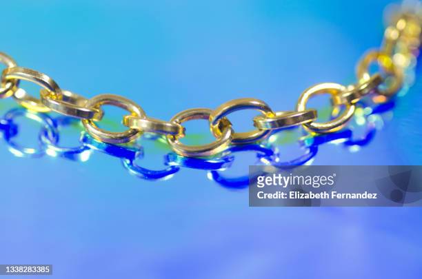 gold chain links on holographic foil - gold chain necklace stock-fotos und bilder