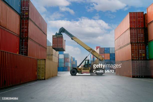 gru che solleva container nel porto commerciale. - crane construction machinery foto e immagini stock