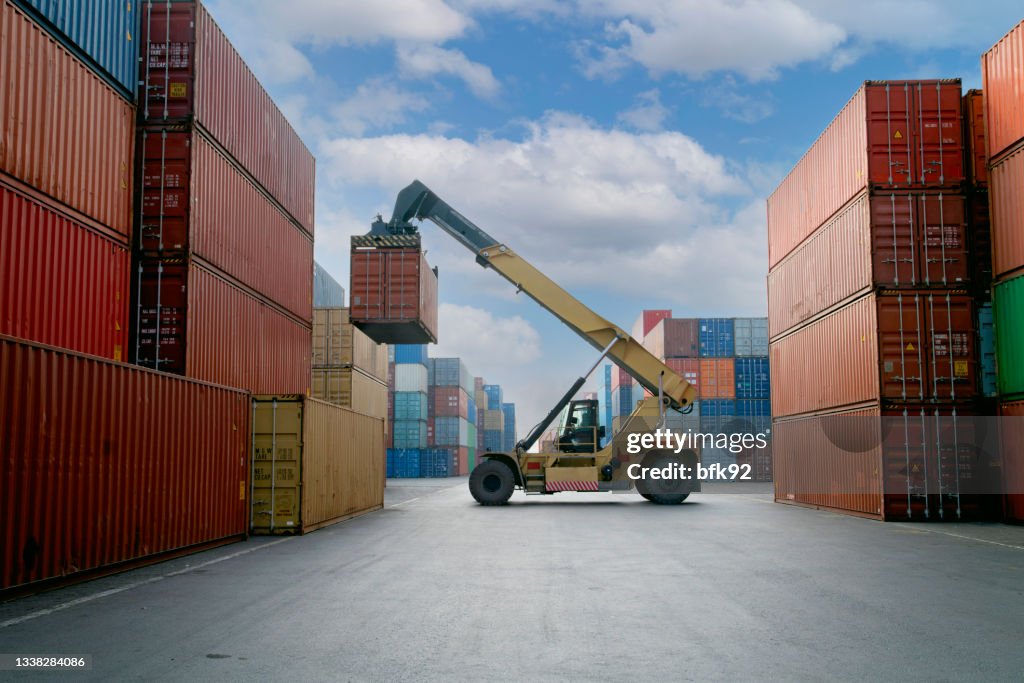 Crane lifting up container in commercial port.